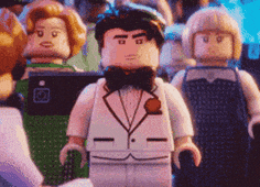 a lego man in a tuxedo is standing in a crowd .