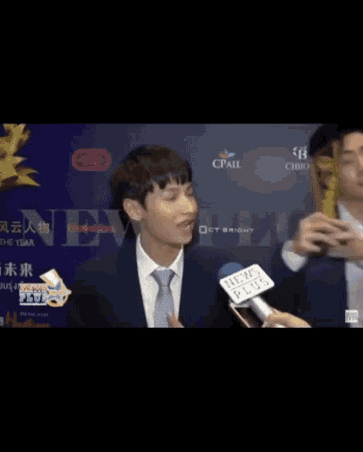 a man in a suit and tie is being interviewed by a reporter