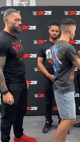 a man in a black shirt is standing next to another man in a black shirt that says 2k25