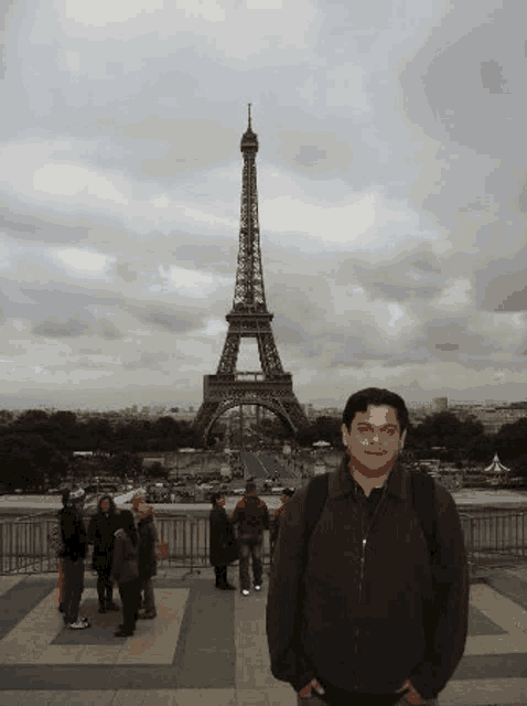 a man is standing in front of the eiffel tower