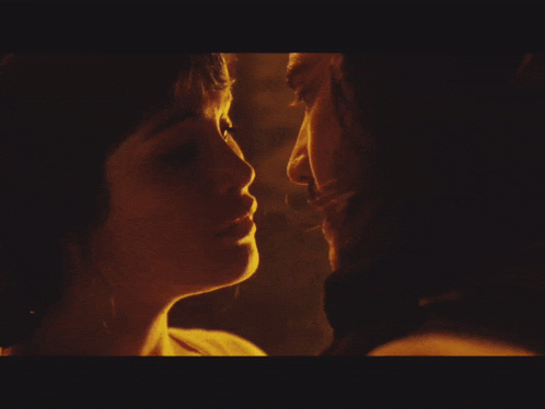 a close up of a man and woman kissing