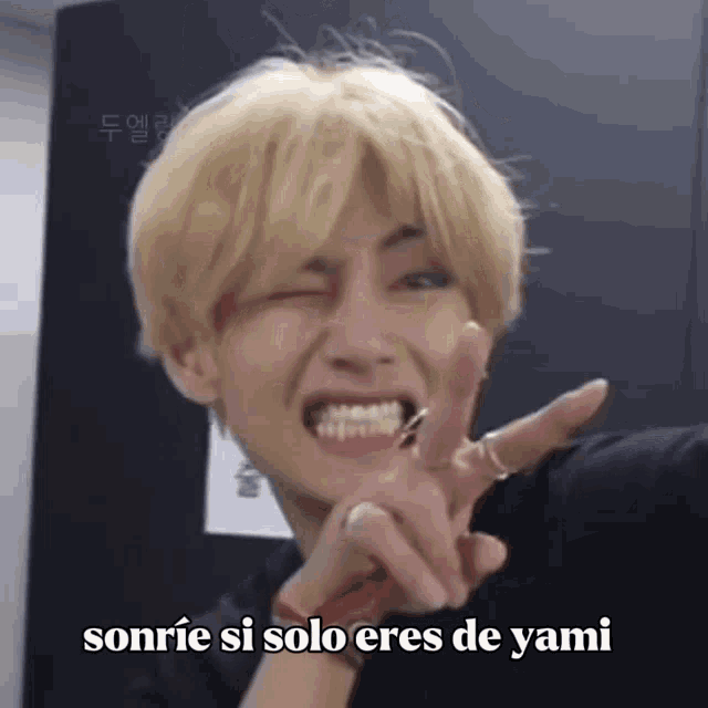 a young man with blonde hair is making a funny face with the words sonrie si solo eres de yami below him