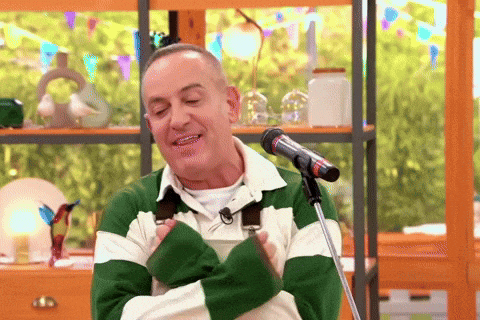 a man in a green and white striped sweater is standing in front of a microphone