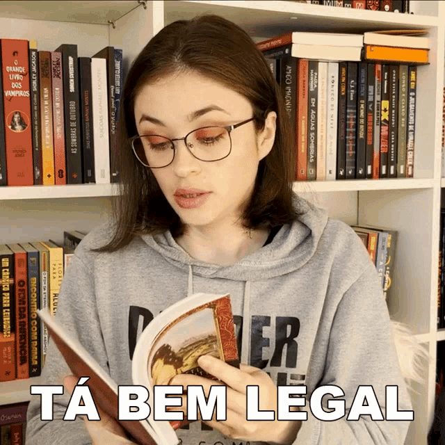 a woman wearing glasses is reading a book and says ta bem legal on the bottom