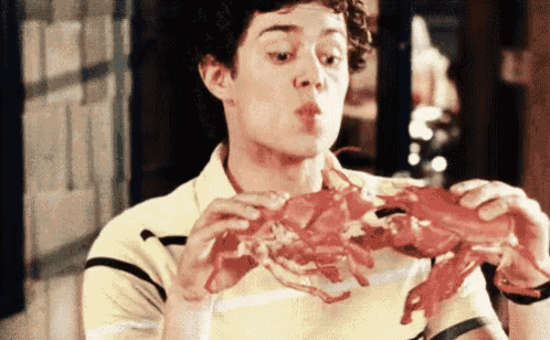 a young man is eating a large lobster in a restaurant .