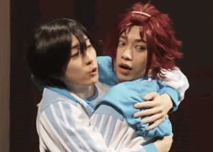 a person with red hair is hugging another person with black hair
