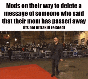 a man in a suit is walking on a red carpet in front of a crowd
