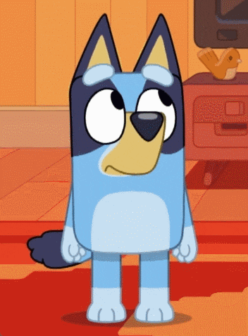 a blue dog with a yellow nose is standing in front of a television
