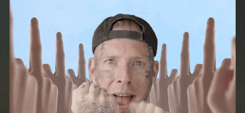 a man with a tattoo on his face is surrounded by a bunch of fingers