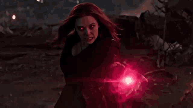 scarlet witch from avengers endgame is holding a red sphere in her hand .