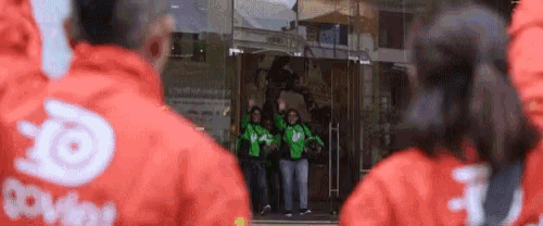 a group of people wearing red and green jackets with the letter o on them