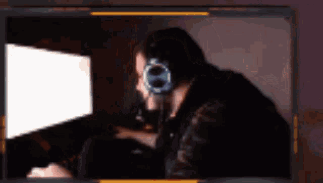 a man wearing headphones is sitting in front of a computer monitor