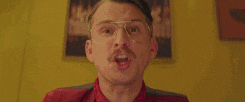 a man with glasses and a mustache says do it or i fucking walk with his finger