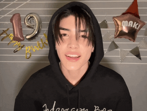a young man wearing a black hoodie with the name maki on it