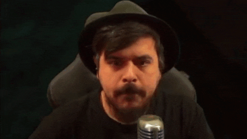 a man with a beard wearing a hat and a black shirt with a dog on it