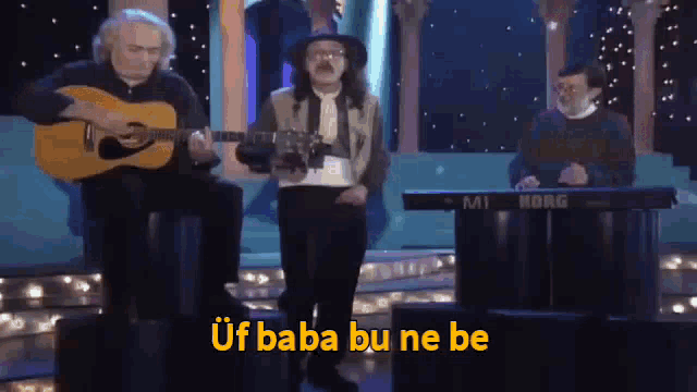 a man playing a guitar and another man playing a keyboard with a korg keyboard in the background