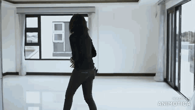a woman is standing in an empty room with the words made in animatica on the bottom right