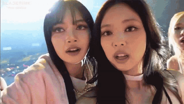 a couple of girls are standing next to each other and talking to each other .