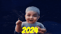 a baby wearing a white hat is pointing at the number 2024