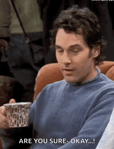 a man in a blue sweater is holding a cup of coffee and saying are you sure okay