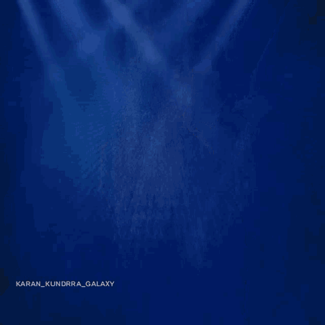 a man in a suit is dancing with the name karan kundra galaxy written on the bottom