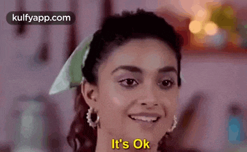 a woman is smiling and saying `` it 's ok '' in a kitchen .