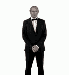 a man in a tuxedo and bow tie is standing with his arms crossed .
