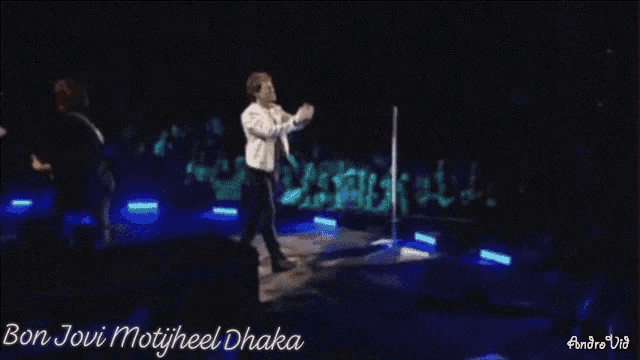 a man singing into a microphone with the words " bon jovi motijheel dhaana " written on the bottom