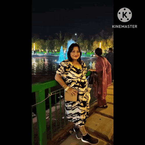 a woman in a red top is smiling in front of a yellow curtain and a sign that says kinemaster