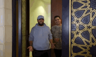 two men are standing in front of a door .