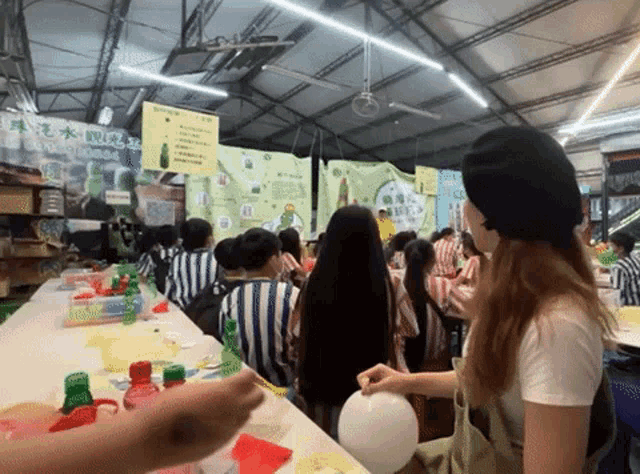 a large group of people are gathered in a room with a sign that says ' a ' on it