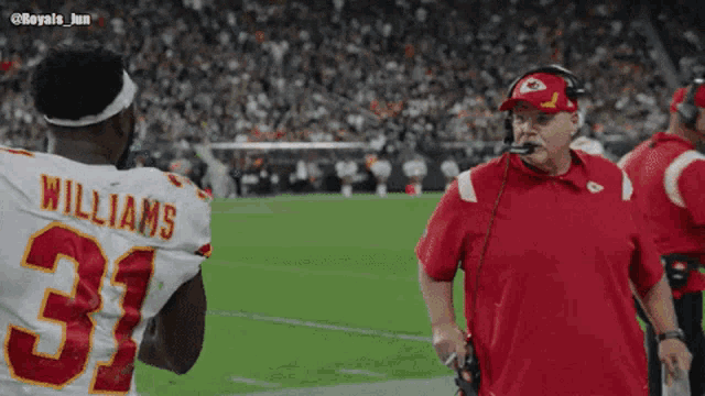 a football player with the number 31 on his jersey talks to a coach