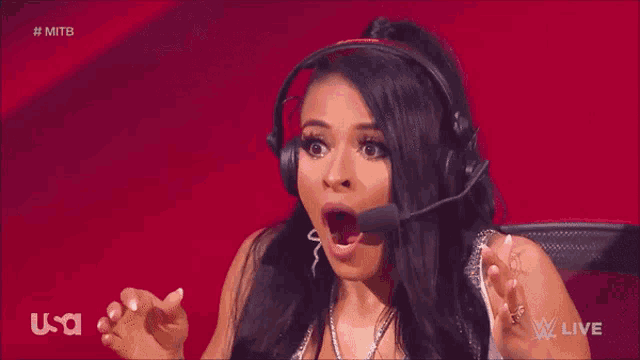a woman wearing headphones and a microphone looks surprised