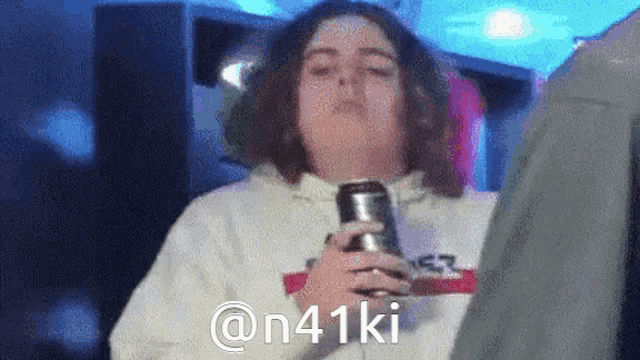 a person holding a can of soda with the hashtag @ n41ki on it