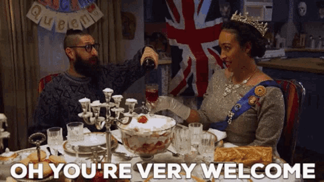 a woman in a crown is sitting at a table with a man pouring wine
