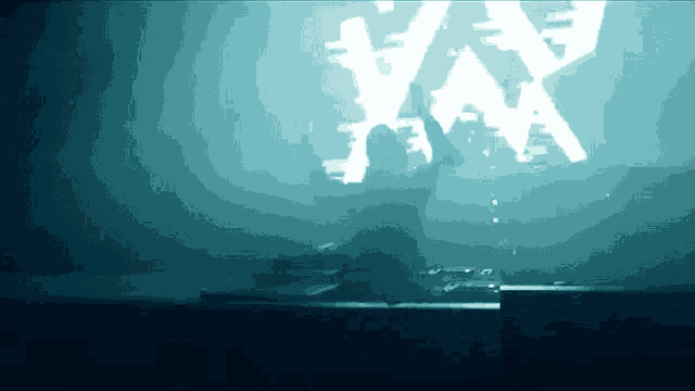 a man stands in front of a large screen that says ' x ' on it