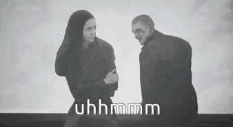 a man and a woman are standing next to each other and looking at each other .