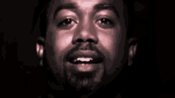 a close up of a man 's face with a beard looking at the camera .