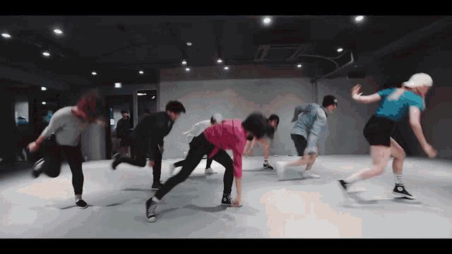 a group of young people are dancing in a room