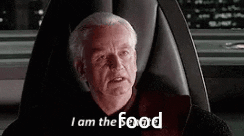a man is sitting in a chair with the words `` i am the food '' written on the screen .