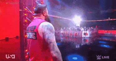 a man in a pink tank top with the word wrestling on it