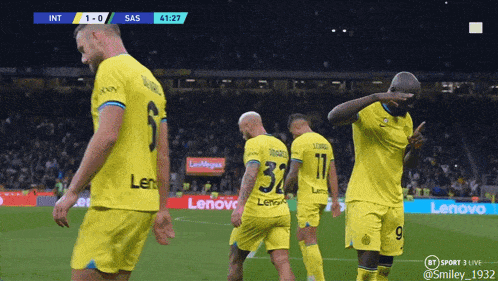 a group of soccer players wearing yellow jerseys with lenovo on the front
