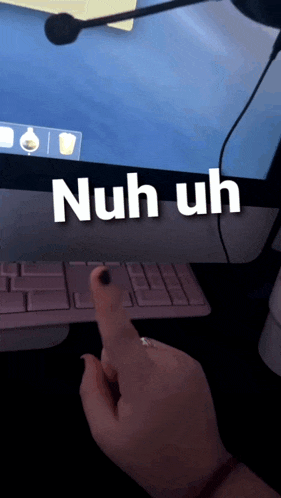 a person 's hand is pointing at a computer screen with the words nuh uh on it