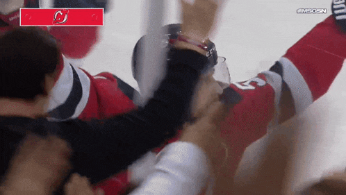a hockey player is being thrown in the air while wearing a jersey with the number 23 on it