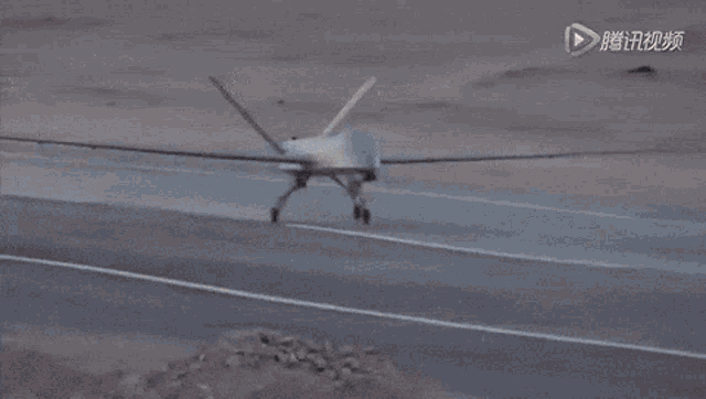 a plane is flying over a desert with chinese writing on the bottom of the screen
