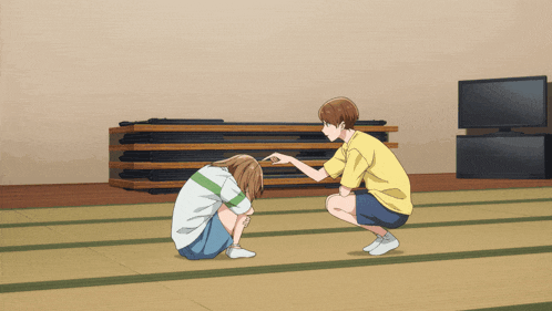 a man in a yellow shirt kneeling down next to a girl in a white shirt