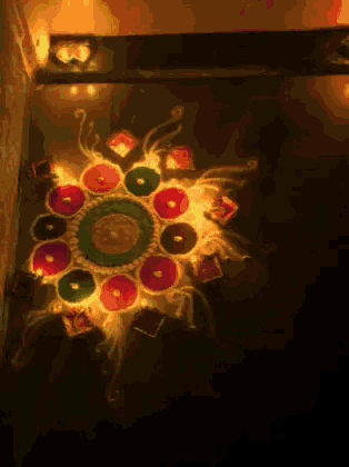 a colorful circular design is lit up with candles