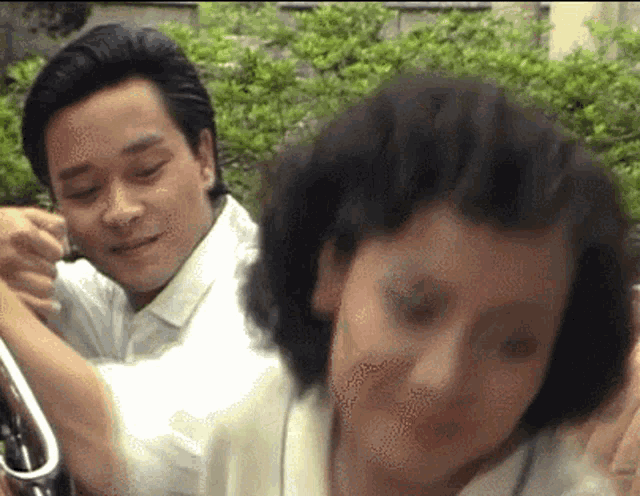 a man in a white shirt is hugging a woman