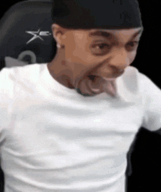 a man wearing a white shirt and a black headband is making a funny face .
