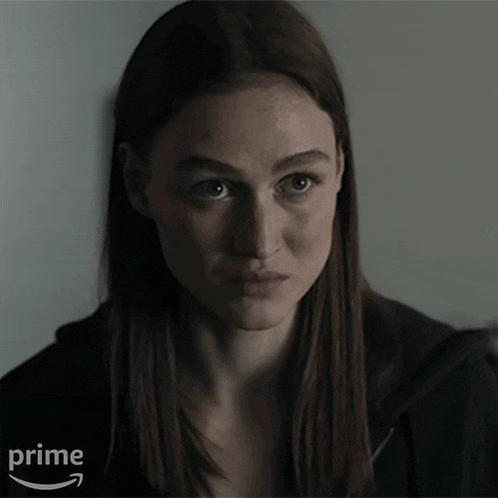 a woman in a dark room with the word please behind her